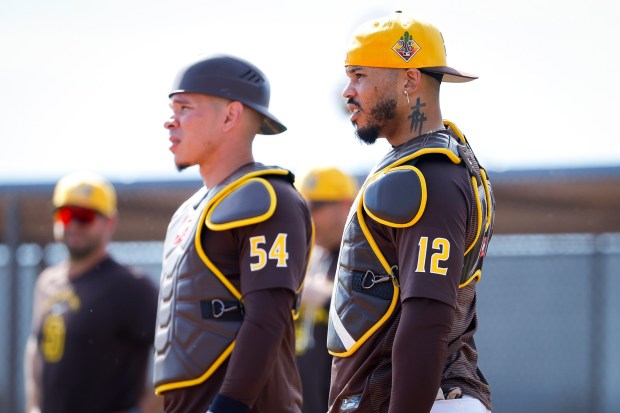 Freddy Fermin #54 and Luis Campusano #12 of the San Diego Padres look on during spring training workouts at the Peoria Sports Complex on Sunday, Feb. 15, 2026 in Peoria, Ariz.(Meg McLaughlin / The San Diego Union-Tribune)