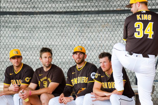 Kyle Hart #68, Jason Adam #40, Joe Musgrove #44, and Nick Pivetta #27 watch Michael King #34 of the San Diego Padres at the Peoria Sports Complex on Tuesday, Feb. 10, 2026 in Peoria, Ariz. (Meg McLaughlin / The San Diego Union-Tribune)