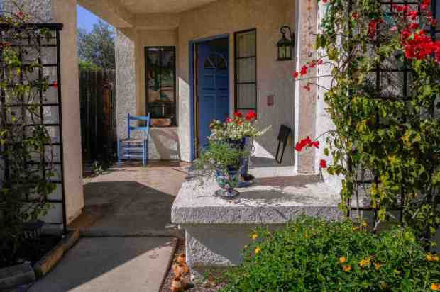 The front entrance welcomes neighbors who often stop by. Chambers has shared both clippings and advice. (Charlie Neuman / For The San Diego Union-Tribune)