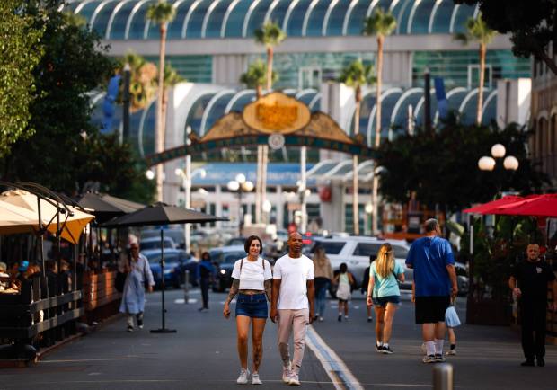 Tourists from Long Beach walk the Gaslamp Promenade on July 23. (Meg McLaughlin / The San Diego Union-Tribune)