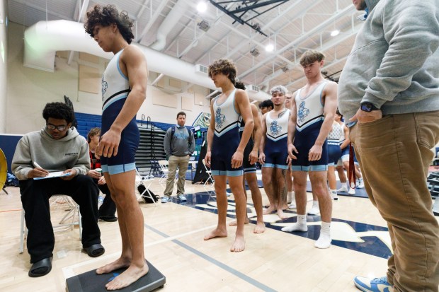 Emilio Escobar stands on a scale during weigh-ins at the CIF San Diego Division 1 championship meet at Del Norte High School on Saturday, Feb. 14, 2026. Escobar weighed 122 pounds. (Kristian Carreon / The San Diego Union-Tribune)