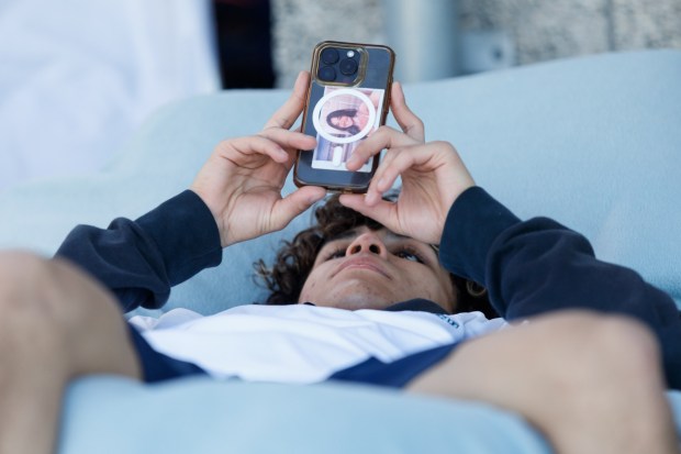 Emilio Escobar browses his phone between matches during the CIF San Diego Division 1 championship meet at Del Norte High School on Saturday, Feb. 14, 2026. (Kristian Carreon / The San Diego Union-Tribune)