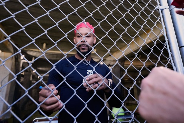 Minnesota Twins outfielder Byron Buxton signs autographs for fans during a spring training baseball workout in Fort Myers, Fla., Sunday, Feb. 15, 2026. (AP Photo/Gerald Herbert)