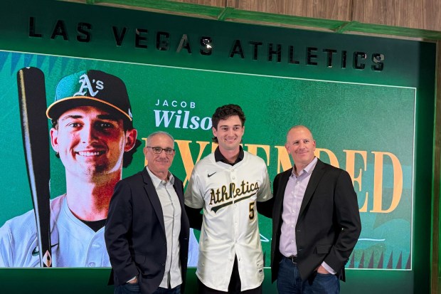 Athletics Assistant General Manager Dan Feinstein, from left, shortstop Jacob Wilson, and General Manager David Forst, pose at a news conference Monday, Feb. 2, 2026, in Las Vegas. (AP Photo/Mark Anderson)
