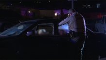 A San Diego County Sheriff's Office deputy talks to a car full of suspected party-goers outside a busted-up vacant party in Spring Valley in January.
