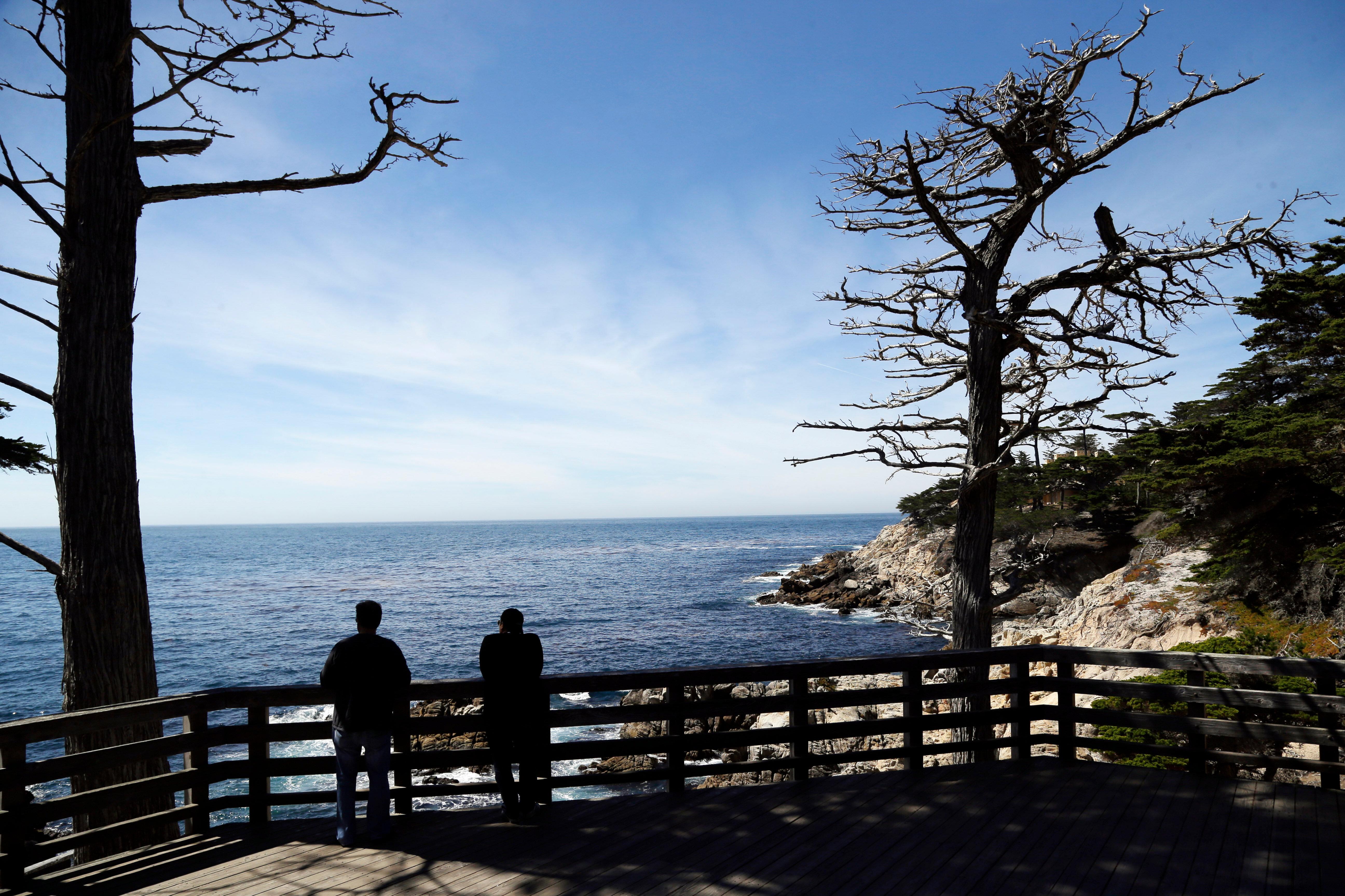 Two visitors enjoy a view of the Pacific Ocean from...
