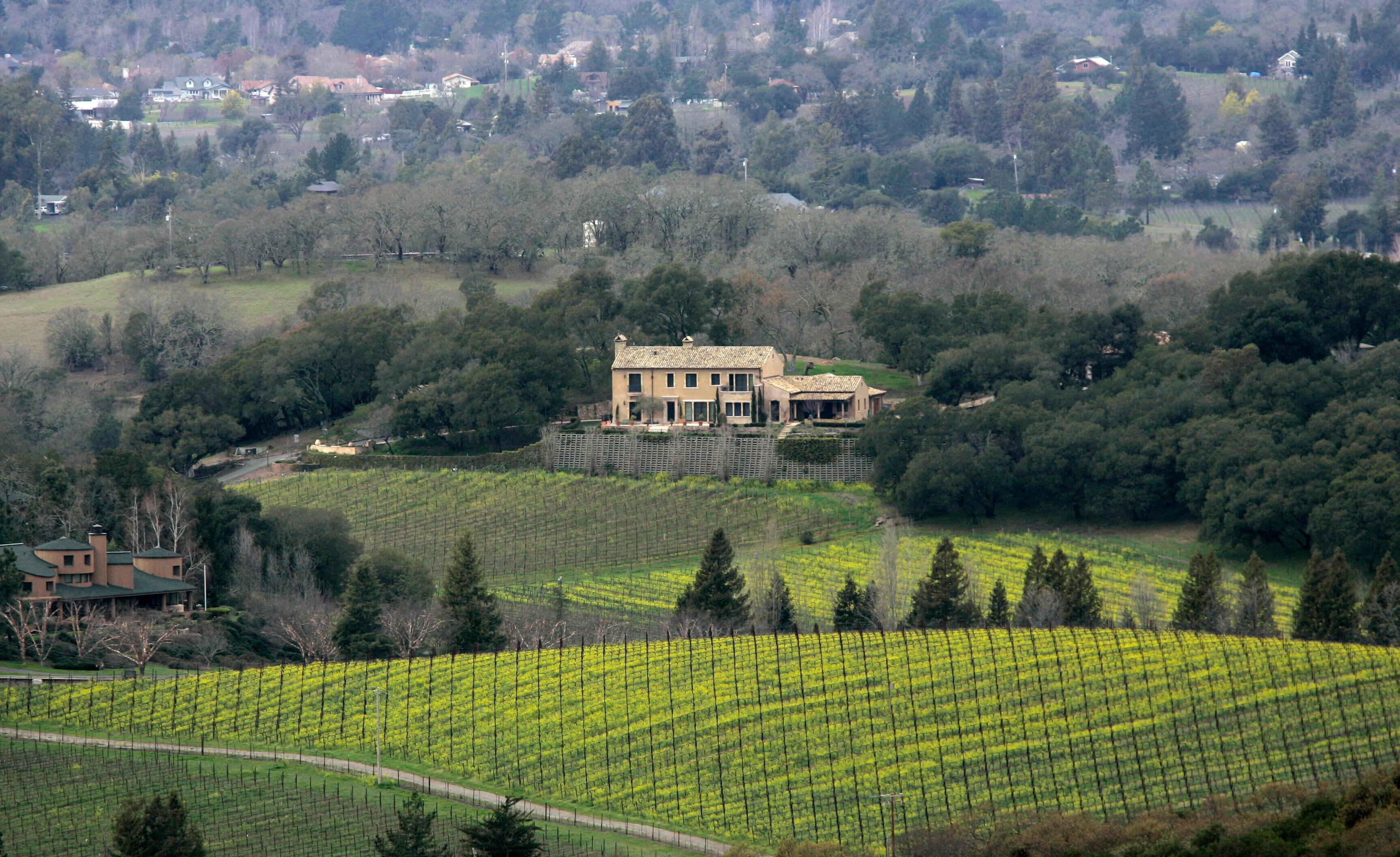 A residence sits on a hilltop overlooking a vineyard in...