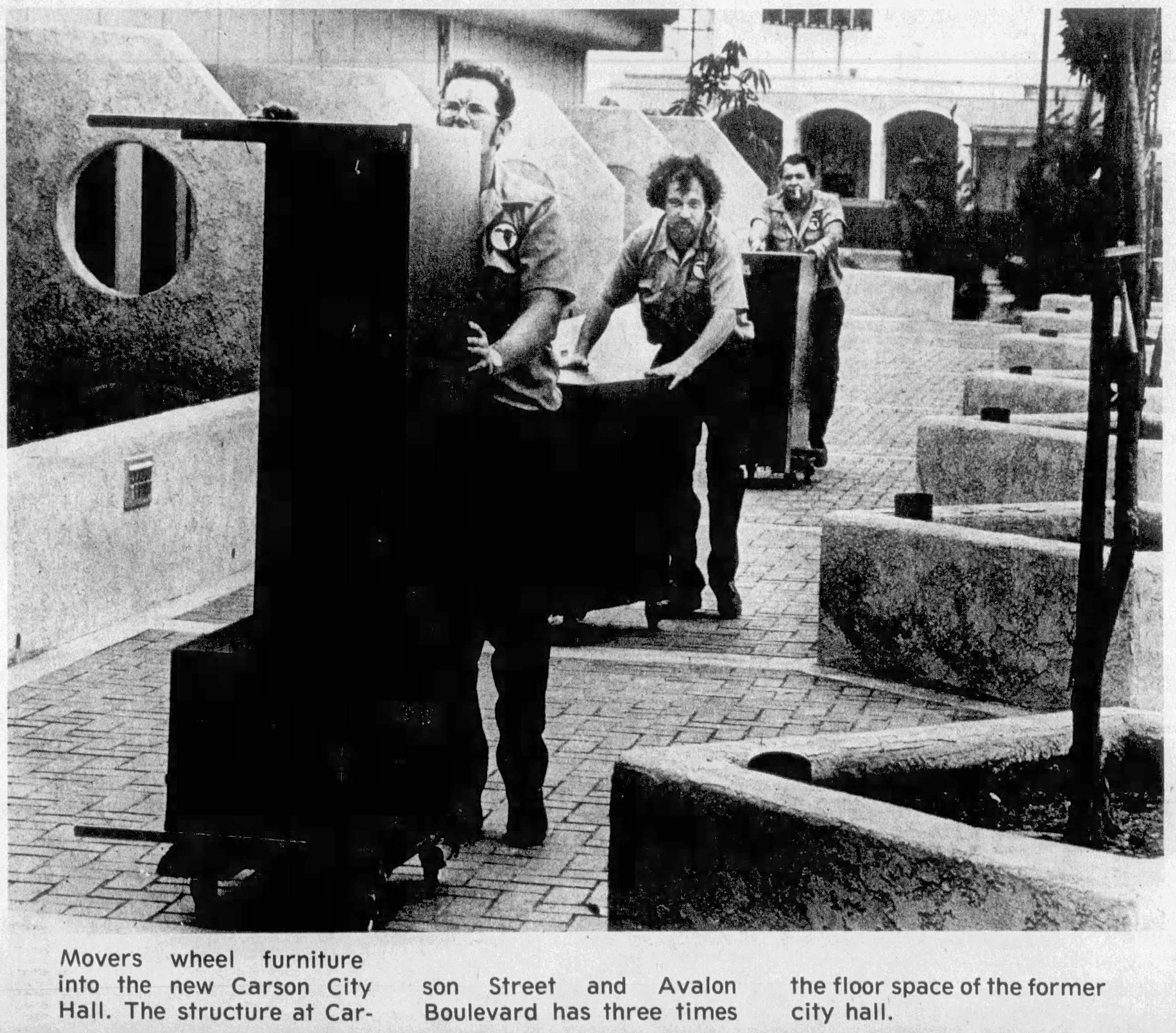 Movers wheel furniture into the new Carson City Hall. The...