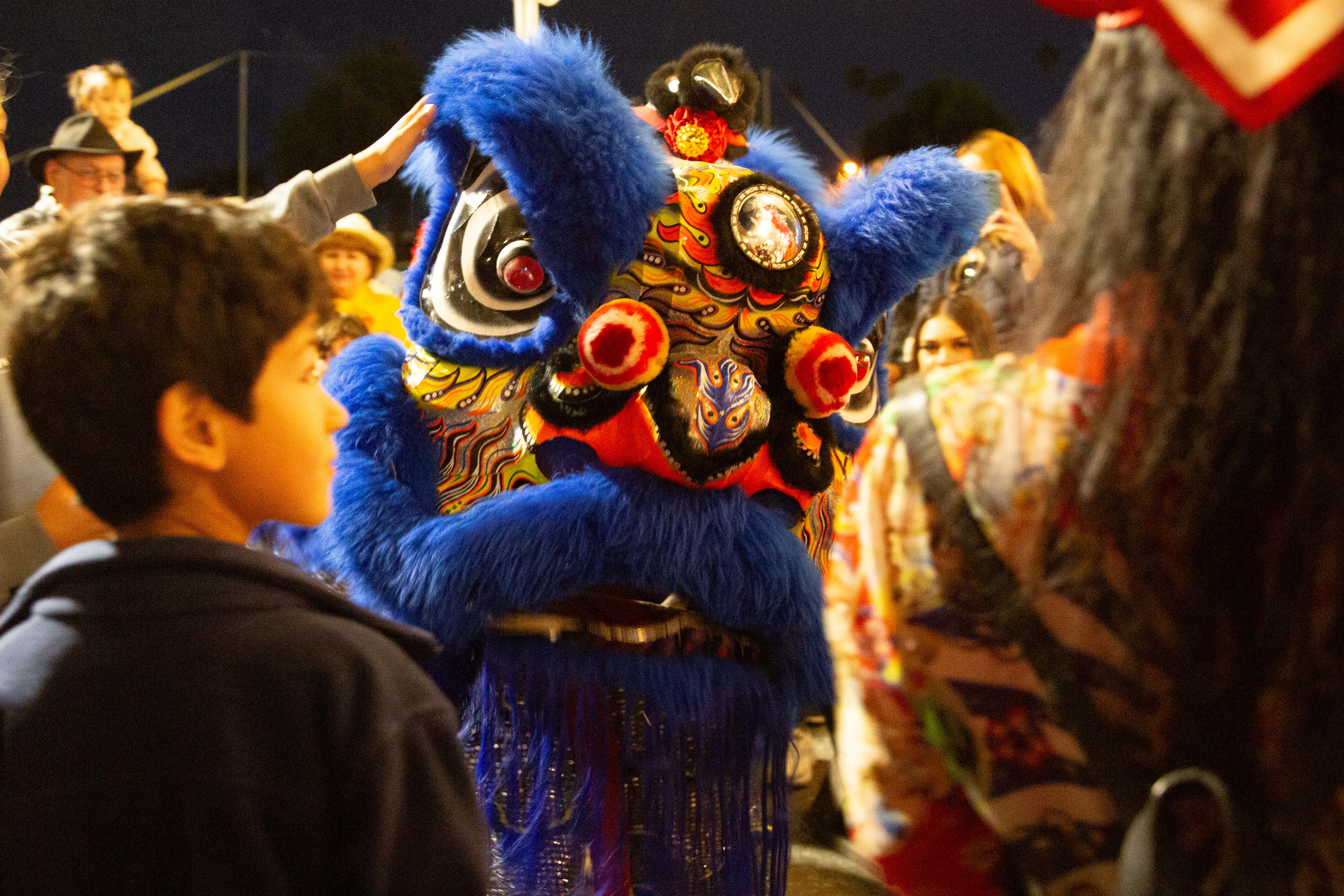 Lion dancers walk through the crowd during their performance at...
