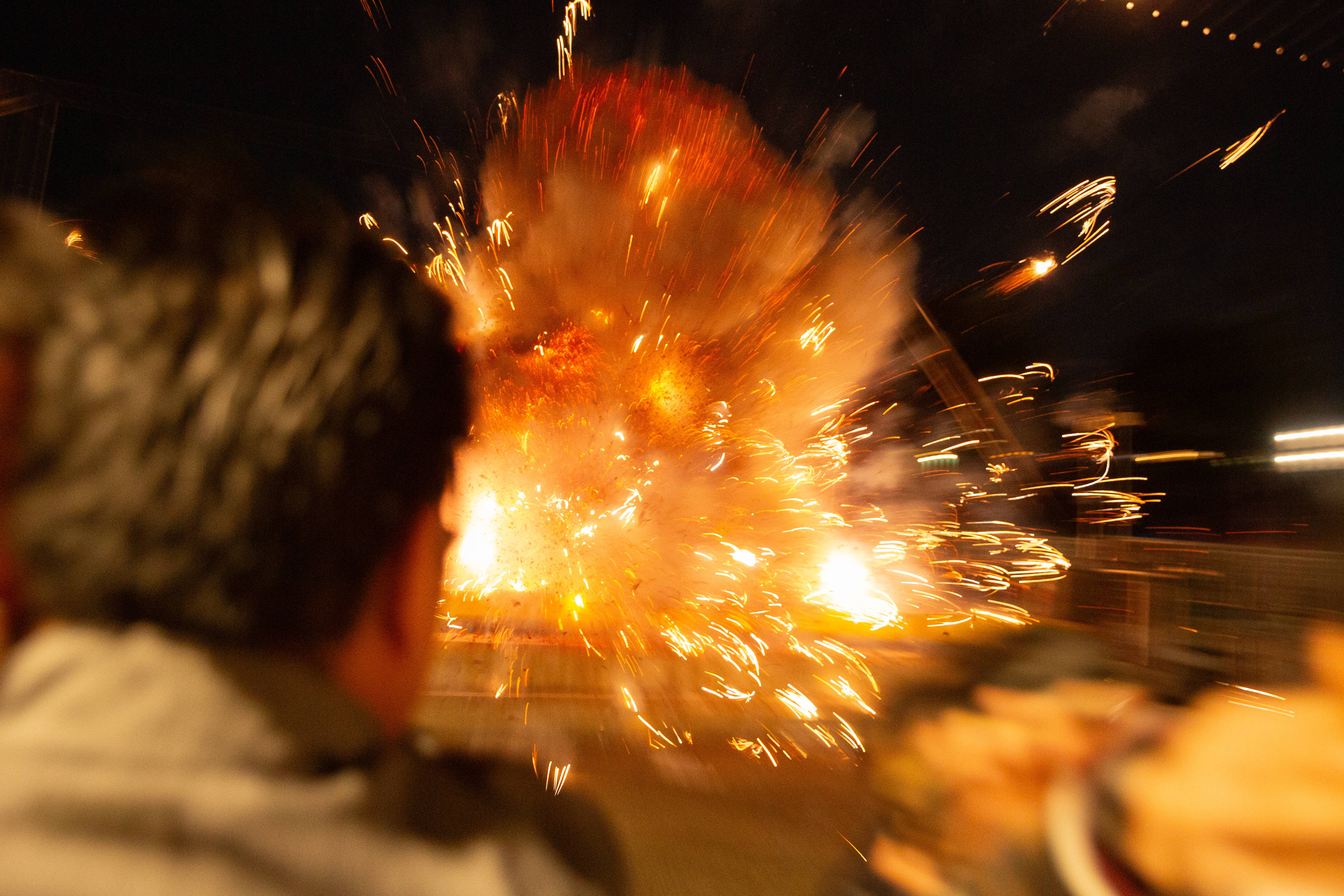 Four hanging lines of firecrackers go off nearly all at...