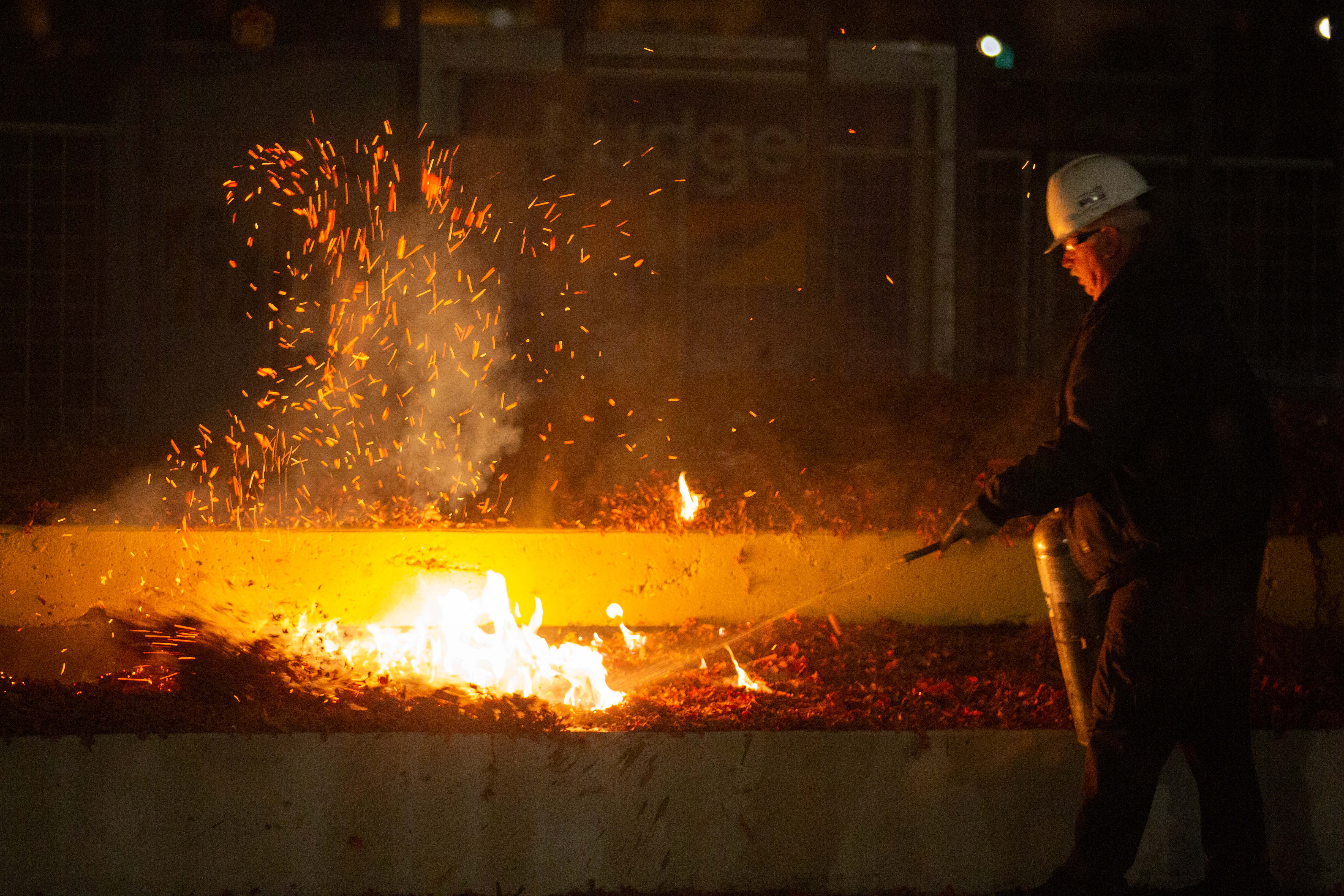 A maintenance crew member puts out a fire sparked by...