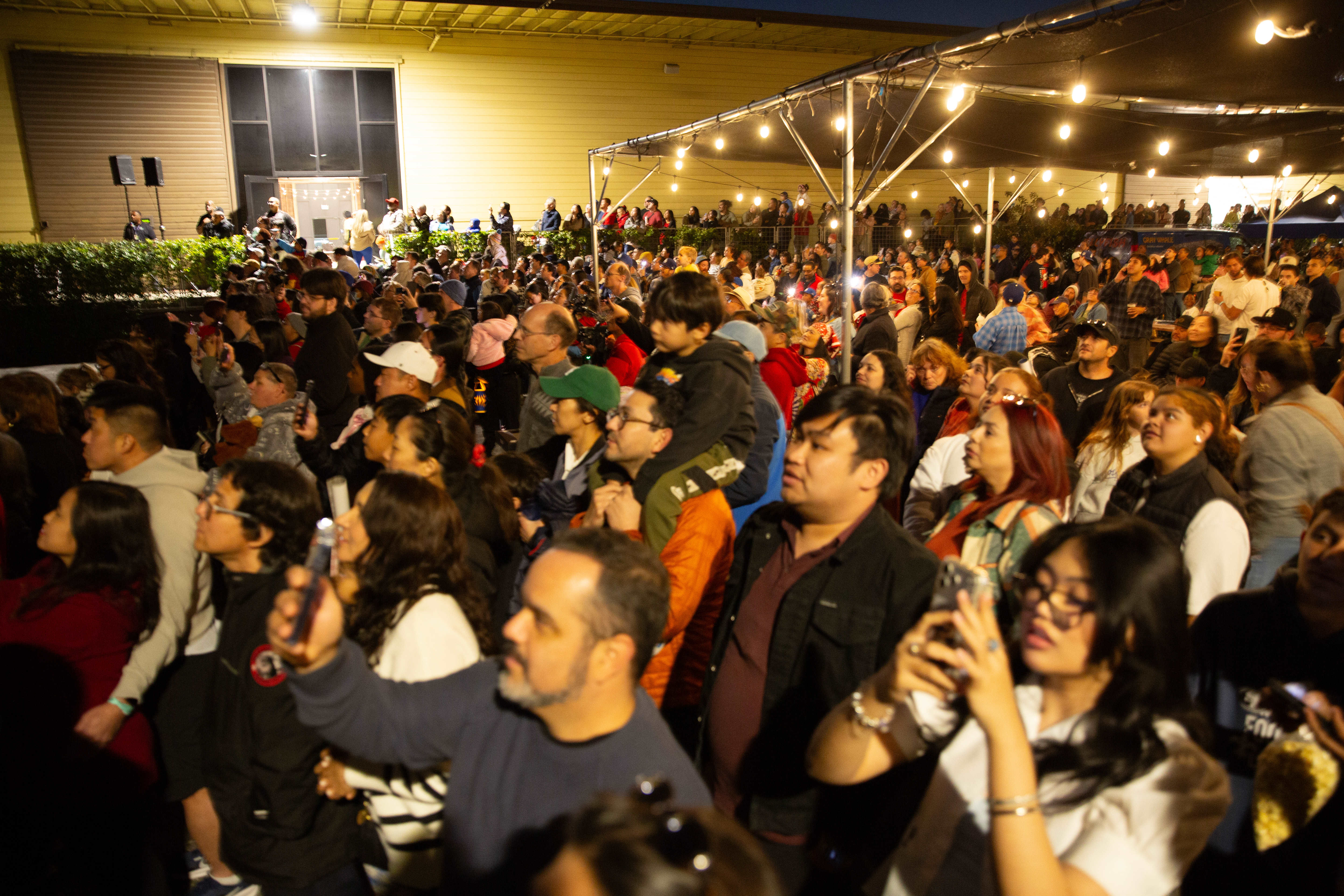Hundreds of audience members watch a drone show during the...