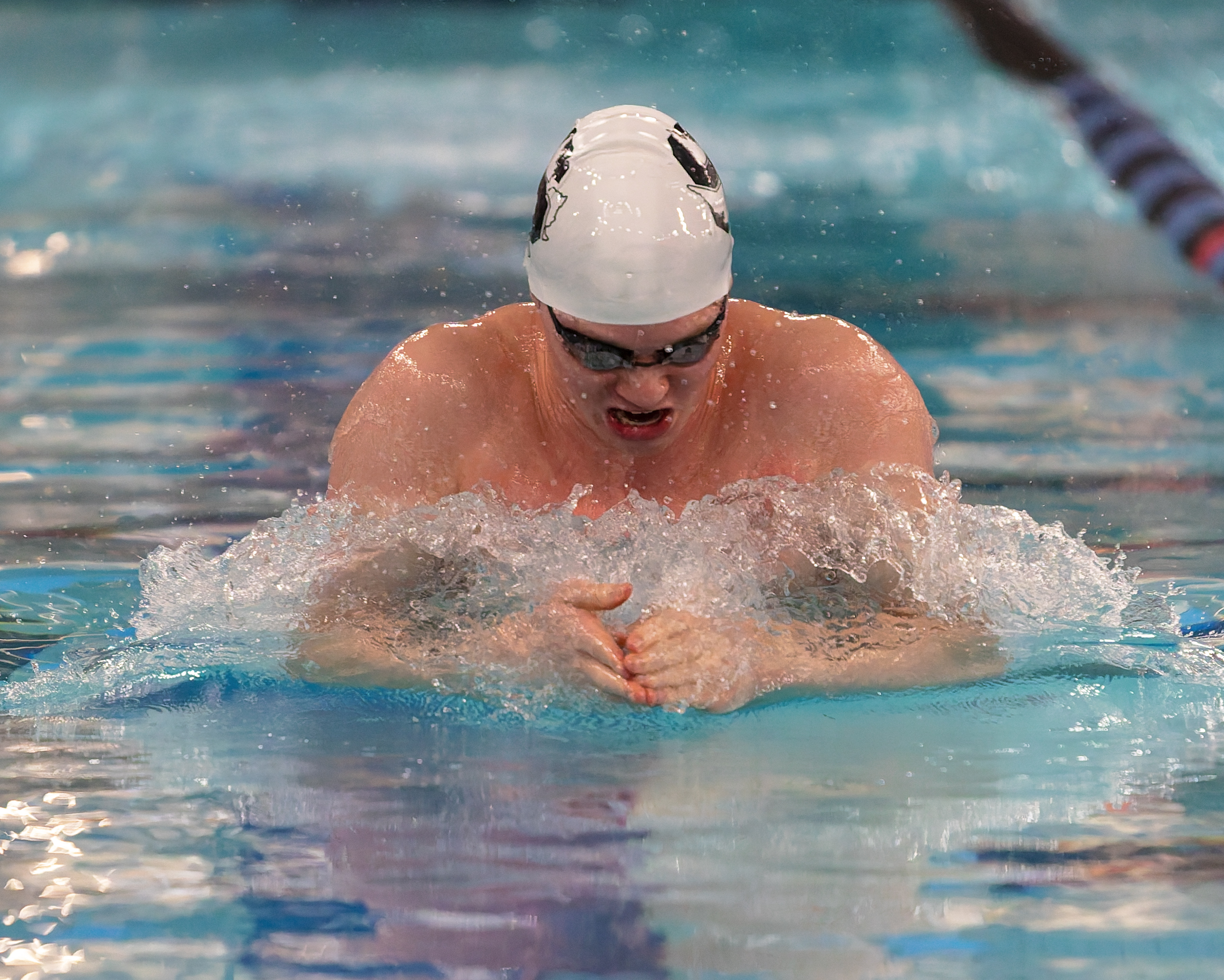 Birmingham Groves' Nate Stebbins swims in the 100-yard breast stroke...