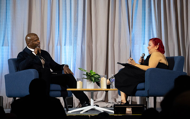 Terry Crews and Rachel Robles sit on stage for an interview in the Titan Student Union. 