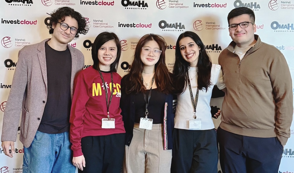 five people standing together at a competition