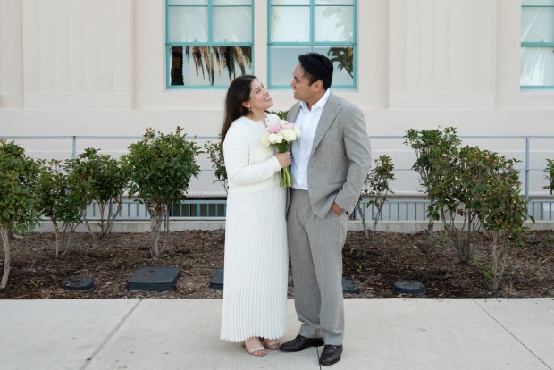 Cristina Michel, 30, and Maurice Basobas, 30, pose for a photo after their civil ceremony just outside the San Diego County Administration Center on Feb. 14, 2026. (McKenzie Patterson / For The San Diego Union-Tribune)