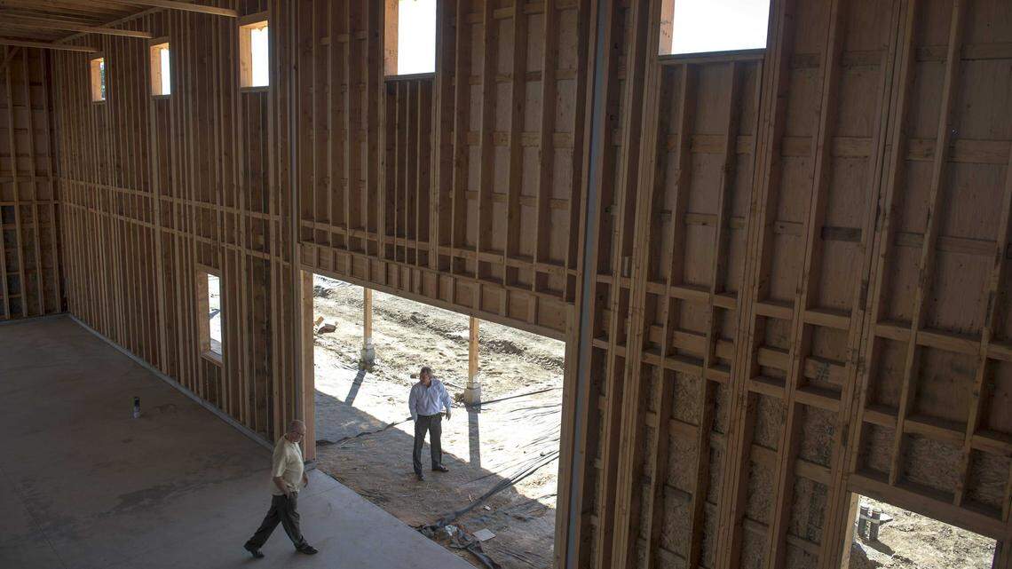 Two men walk through the barn under construction at The Cannery housing project in Davis during construction. The Cannery’s approval in 2013 was controversial, but today Davis faces renewed pressure to approve housing like Village Farms as shrinking school enrollment reflects the city’s declining population of young families.