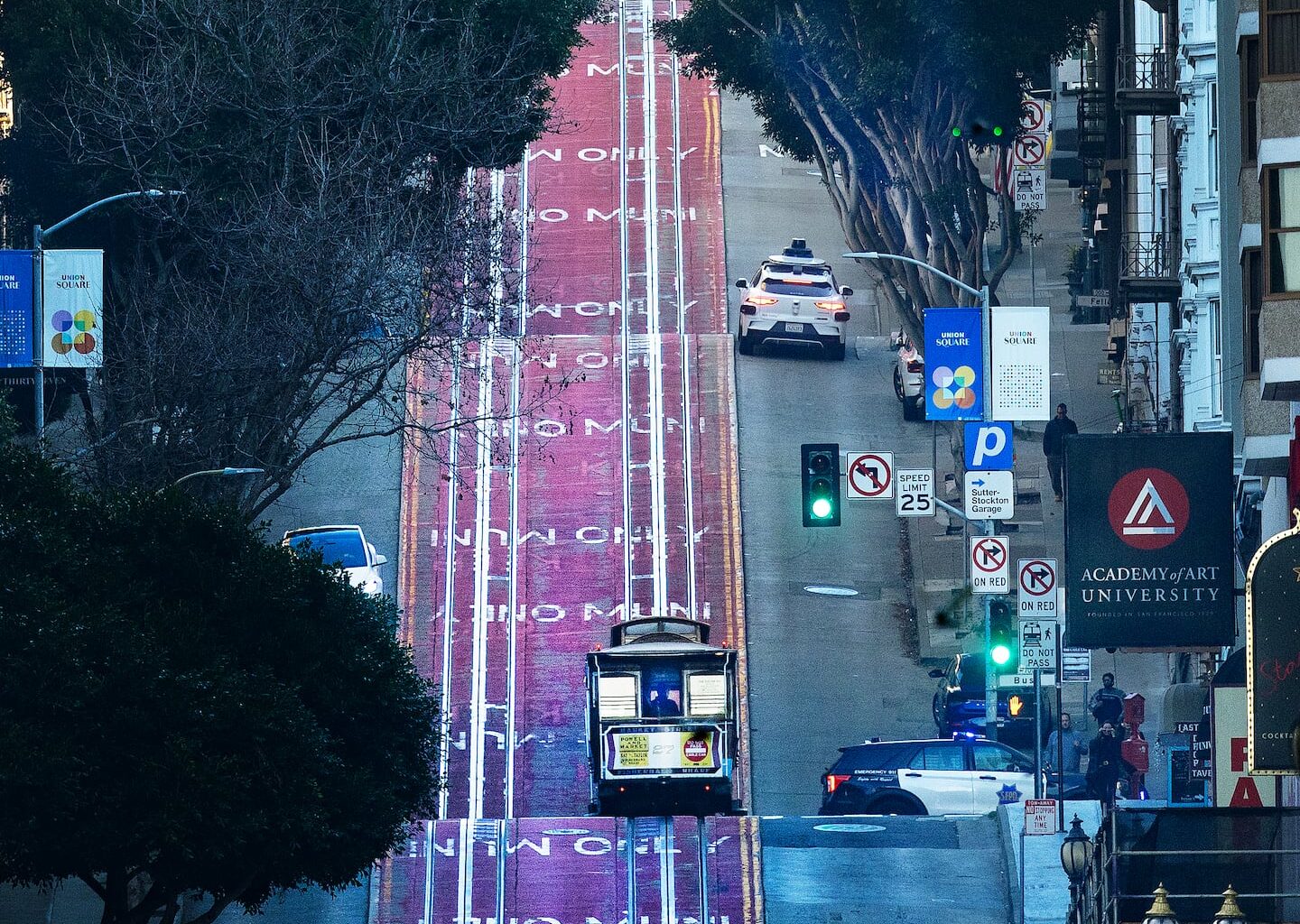 A cable car and a Waymo head up Powell Street in San Francisco.