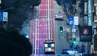A cable car and a Waymo head up Powell Street in San Francisco.