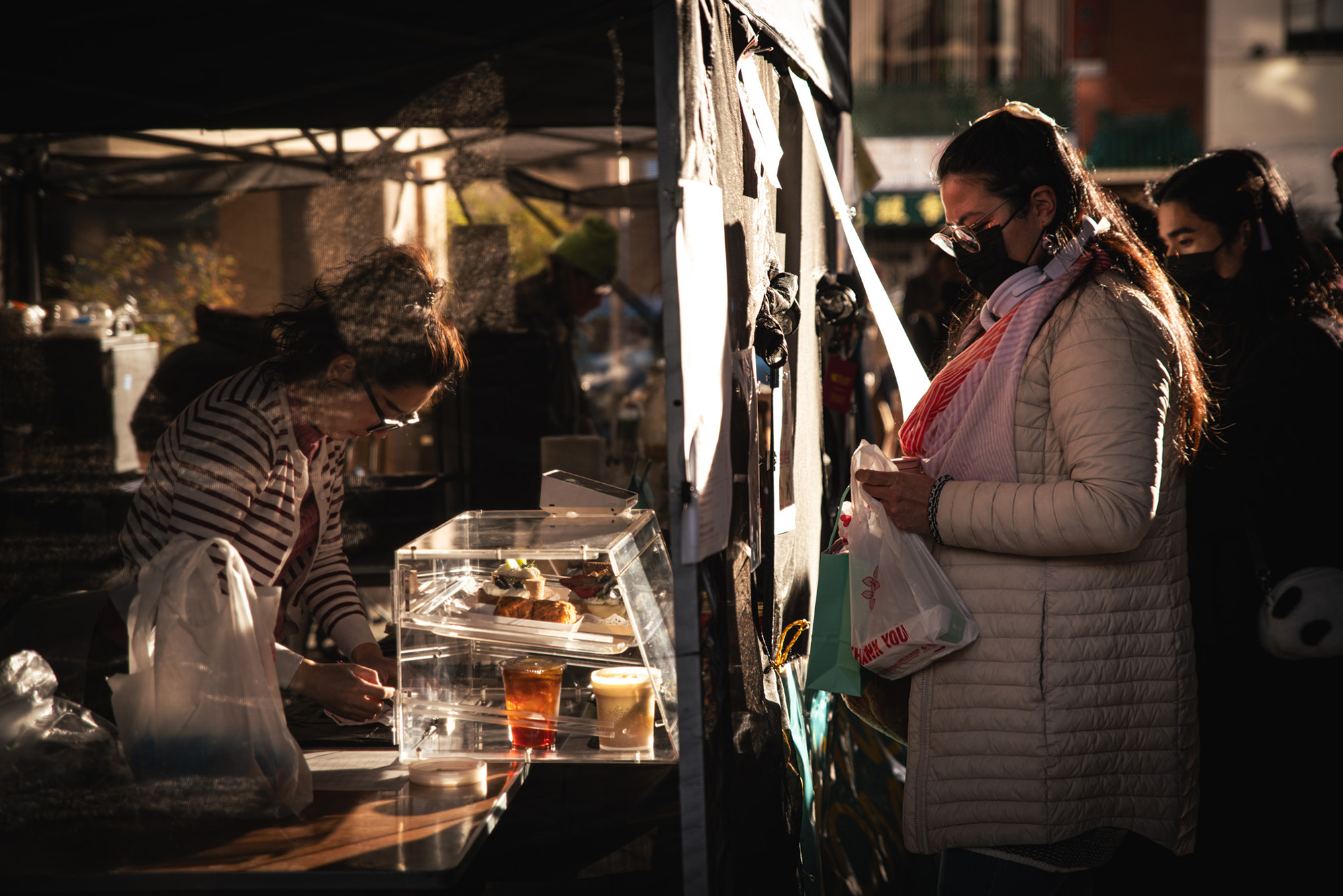 A customer buying food from a festival vendor at night.