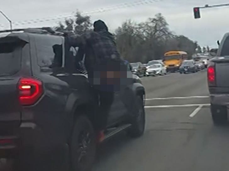 022726_man_hanging_from_cars_side