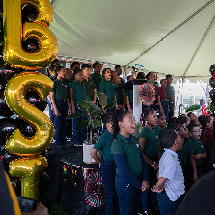 several elementary age children singing to an audience