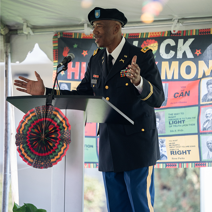 adult male in military uniform talking at a podium