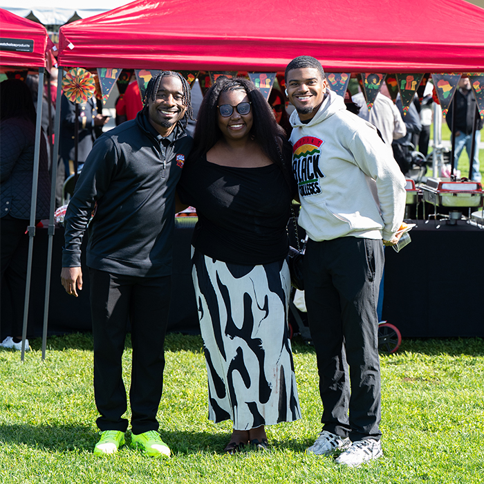 three event participants standing together on a lawn area