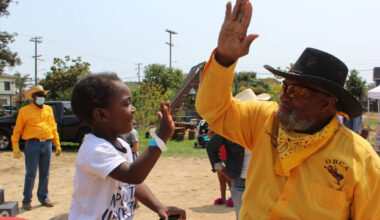 The Oakland Black Cowboys Association will hold an event to teach children the love of riding at Fairyland on Feb. 14. Here, a member of the OBCA high-fives a young rider at an event in 2021. Facebook photo.