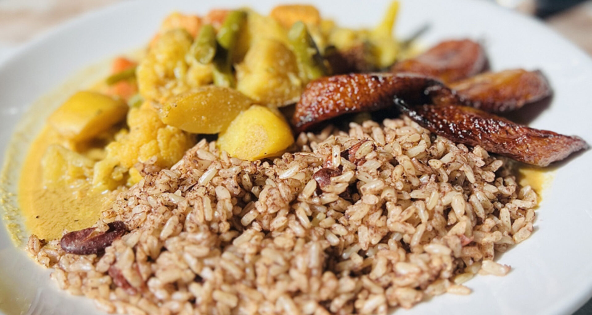A plate of Jamaican rice and peas with vegetable curry.