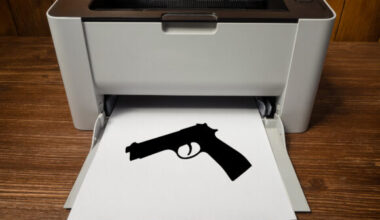 A gun printed on a sheet of paper exiting the printer