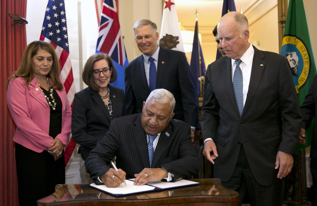 Gov. Jerry Brown, right, watches as Prime Minister of Fiji...