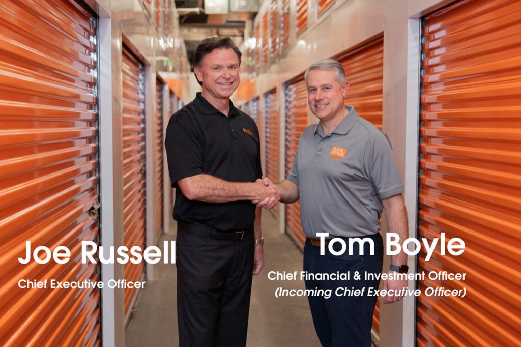 Joe Russell and Tom Boyle shaking hands in a storage facility.