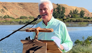 man at a podium in front of a river