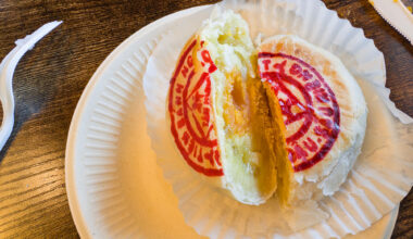 A flaky Asian pastry cut in half to reveal its durian and salted egg yolk filling.