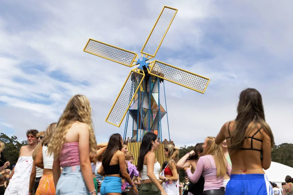 Fans gather beneath the windmill during the first day of the Outside Lands music festival in Golden Gate Park. (Jessica Christian/Jessica Christian / The Chronicle)