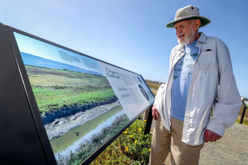 Coastal conservationist Mike McCoy looks at a new interpretive sign at the Tijuana Estuary in Imperial Beach.