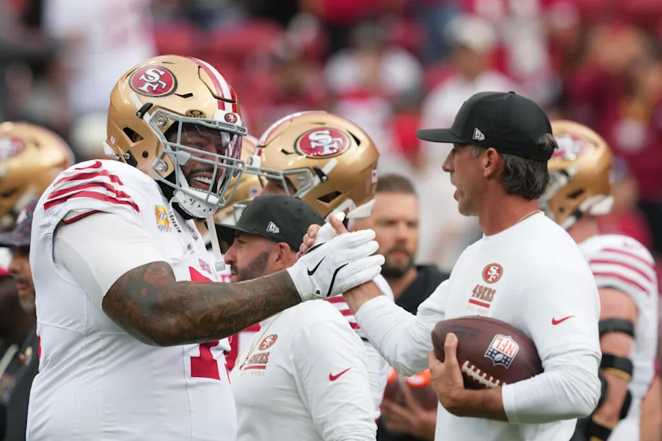 Sep 28, 2025; Santa Clara, California, USA; San Francisco 49ers offensive tackle Trent Williams (left) greets head coach Kyle Shanahan (right) before the game against the Jacksonville Jaguars at Levi’s Stadium. Mandatory Credit: Darren Yamashita-Imagn Images