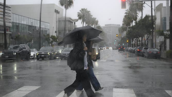 CALIFORNIA, USA - FEBRUARY 16: Women cross the street in Beverly Hills during heavy rain in Los Angeles, California, United States on February 16, 2026.