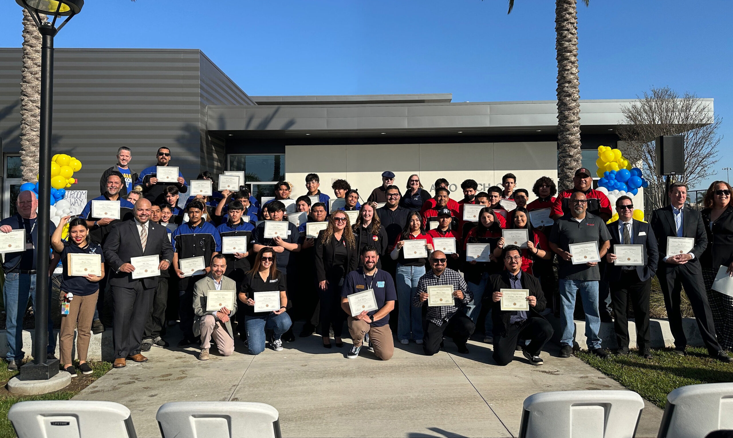 Automotive Pathway students from Valley High and Santa Ana High School stand with pathway advisors, Santa Ana Unified leaders and Superintendent Dr. Lorraine M. Perez during the Community Garage event at Valley High School. Students hold certificates presented during the event.