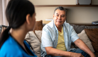 Mature man talking with his nurse during consultation at nursing home