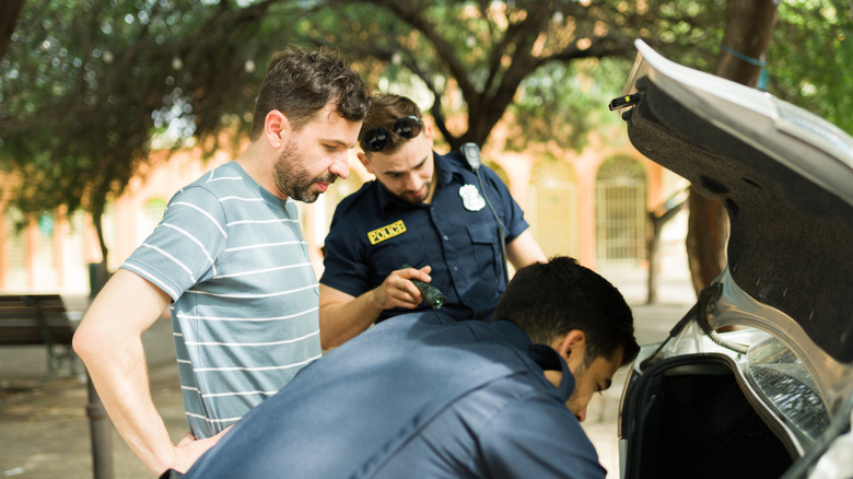 Police searching the trunk of a car