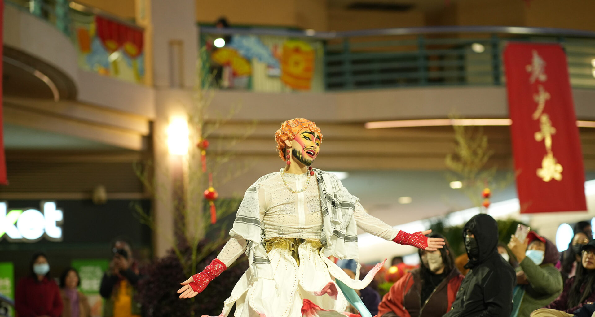 A drag king performer dances in a crowded plaza.