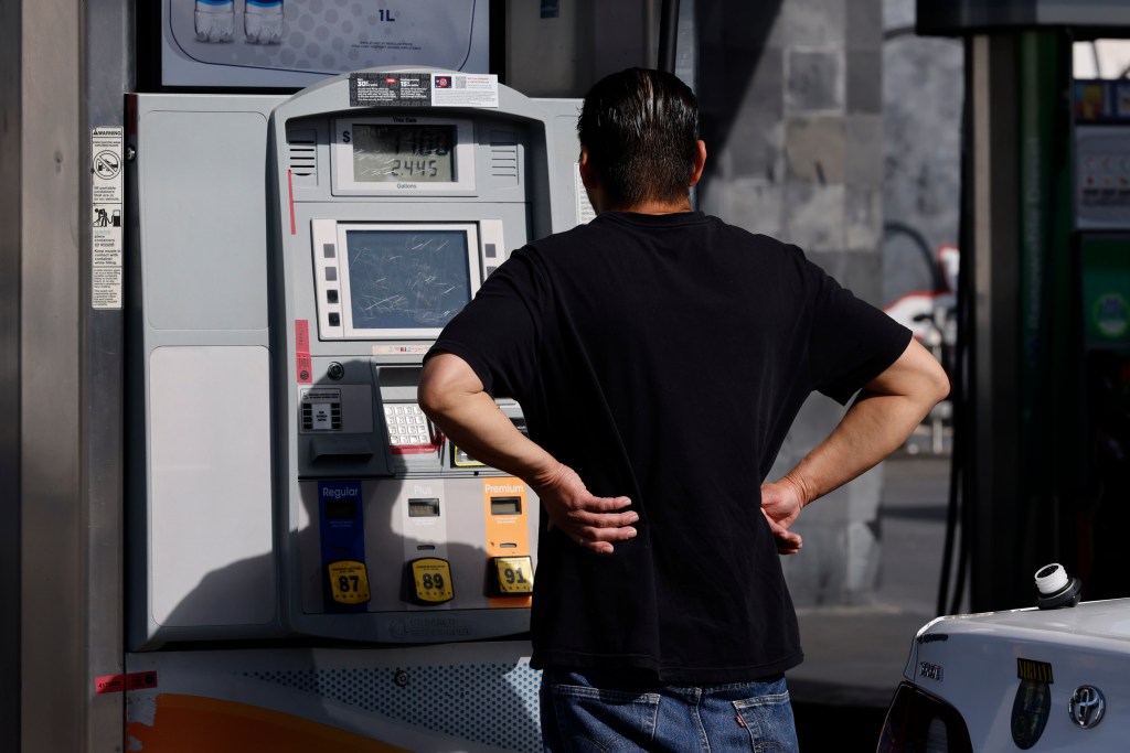 A man filling his gas tank at a 76 gas station in Los Angeles.