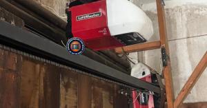 Close-up of a technician installing rust-proof, high-cycle torsion springs on a garage door in a coastal Long Beach home.
