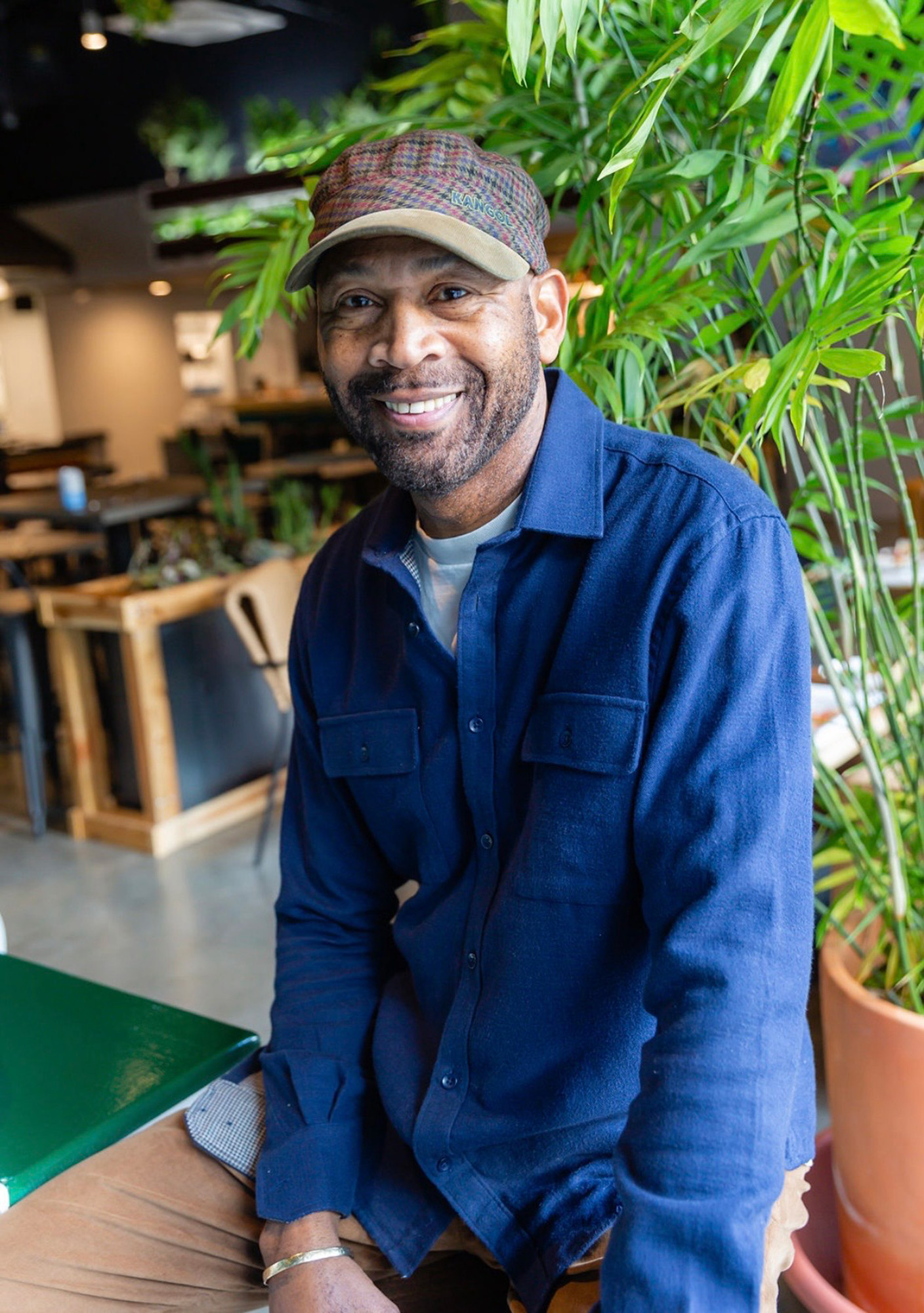 Portrait of a chef in a baseball cap posing in his restaurant.