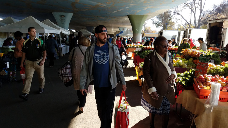 People shop at a farmers' market under a highway in Sacramento.