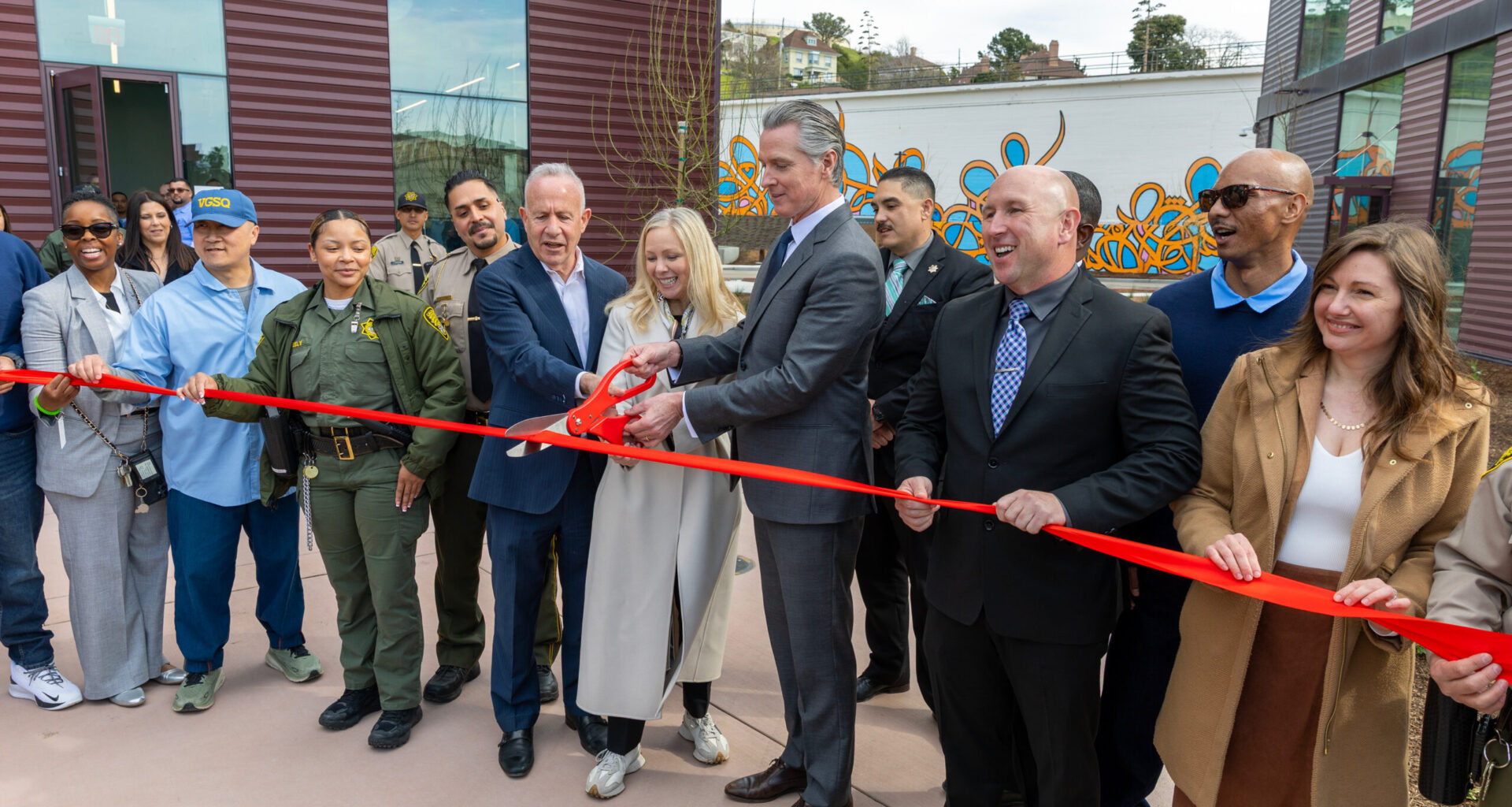 A photo of Governor Newsom and others cutting a ribbon at the San Quentin Learning Center
