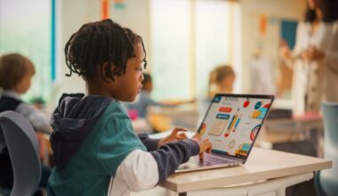 Image of a young Black student working on a laptop in classroom