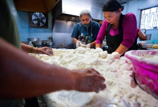 Sophia Estudillo (l) from Las Cuatro Milpas in Barrio Logan and Erica Gonzalez (r) mix and prepare fresh flour tortillas to cook for the lunch crowd.  (Nelvin C. Cepeda / The San Diego Union-Tribune)